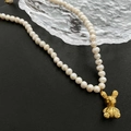 Baroque pearl necklace with a vintage golden bear pendant on a black background - 02-B15 Titanium Steel Rabbit Pendant Natural Pearl Necklace