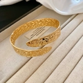 Detailed macro view of the gold hollow embossed floral pattern on this open cuff bracelet - Gold Arm Cuff
