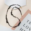 Detail of eyewear chain featuring black stones, golden beads and striped tube accents - Black