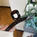 Dettaglio di una grande pinza per capelli in resina tartarugata con molla resistente - Rosso Marrone Lucido