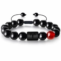 Detalle macro del dije de Aries en pulsera de cuentas tejidas negras y ágata roja - Aries