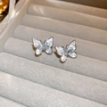 Macro shot of silver butterfly stud earrings with white zircon on grey velvet box - 925 Silver Needle Butterfly Crystal Studs