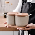 Beige ceramic spice jar set with bamboo lid and spoon held by hands in kitchen - Semicircle Seasoning Jar 2-Pack