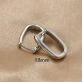 Dettaglio macro di orecchini a U in argento da 18 mm su elegante raso champagne - Argento / 18mm