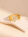Dettaglio di un anello a stella dorato con strass bianchi su un supporto in pietra - Regolabile / Anello in Zirconia a Stella Cava