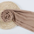 Brown chiffon hijab scarf with fine rolled edges displayed on a woven round mat - 130