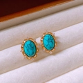 Detalle de pendientes turquesa ovalados con halo de circonitas en estuche de terciopelo - Dorado