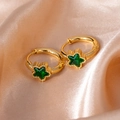 Detail of 18K gold star earrings featuring emerald green crystals on satin fabric - Star Zircon / Green