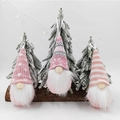 Tre gnomi natalizi in maglia con cappelli a fiocco di neve su legno e luci festose - Rosa/Set di 3
