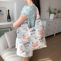 White canvas tote bag featuring colorful cartoon prints and wide shoulder strap - White Canvas Lucky Avocado