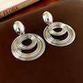 Dettaglio di grandi orecchini a spirale geometrici in argento su pelle scura - Ago in Argento S925/Lega / Argento