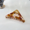 Detail van amberkleurige haarklem met hol driehoekig ontwerp en gouden metalen veer - 11.5cm (Groot) / Transparant Geel Bruin Marmer