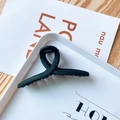 Pince à cheveux croisée noir mat pour femme présentée sur un plateau blanc - Croisé / Noir Solide