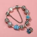Detail of silver beaded bracelet featuring blue enamel charms and star moon pendant - Sl023318/1216-14 / 16cm