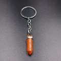 Detail of a hexagonal orange sandstone crystal pendant on a silver metal keychain ring - Gold Sandstone