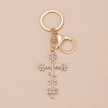 Portachiavi a croce dorata con strass brillanti su sfondo beige accogliente - Kc Oro 5377