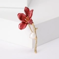 Detailansicht der eleganten roten Lilienbrosche mit goldenem Stiel und weißer Perle - Rot