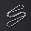 Silver Cuban link chain with gold beads and lobster clasp on black background - 3.2mm Round Snake Chain With Gold Beads Necklace