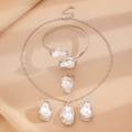 Vista detallada de joyería con perlas barrocas sobre fondo de seda beige elegante - Juego de joyas de perlas artificiales barrocas, 4 piezas (Collar) / Plateado