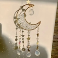 Handmade moon suncatcher with amethyst and crystal prisms reflecting rainbow light - M6-Opalite