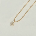 Collana dorata con pendente a lettera D decorato con piccole perle bianche su grigio - Lettera D