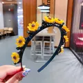 Dettaglio di fermagli a girasole su cerchietto nero, misura del diametro di 11,3 cm - Fiore giallo
