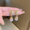 Vintage golden textured round earrings with white pearl pendants shown on a finger - 29# Silver Pin - Gold Round Pearl