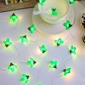 Guirnalda de luces LED navideñas de acebo envueltas alrededor de una taza y plato blanco - Piña de Pino de Navidad