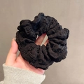 Minimalist black oversized fabric scrunchie with ruffled texture held in hand - Black