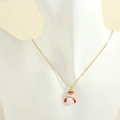 Close-up of golden snowman necklace with white drip oil enamel and colorful zircon stones - Snowman