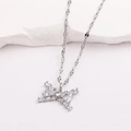 Détail d'un pendentif papillon argenté orné de zircons sur une surface texturée - Style 3-Noeud Papillon Zircon Carré Or Blanc