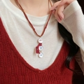 Close-up of snowman pendant with red tassel scarf and adjustable cord on model - Brown Cord Red Scarf Snowman Style