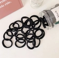 Detalle de gomas de pelo negras de alta elasticidad con tarro de almacenamiento minimalista - Negro