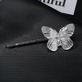 Macro di una molletta a farfalla in metallo argento con ali 3D su pelle nera - Stile Farfalla Media-Argento