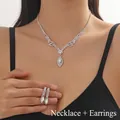 Detail showing elegant bridal jewelry set with v-shaped crystal necklace and teardrop earrings - Necklace And Earring Set (JXTL21082)
