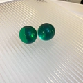 Vista macro de pendientes de bola de resina verde translúcida sobre superficie blanca - Pendientes de Botón Redondos de Resina Verde / Verde