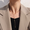 Minimalistische goldene Y-Halskette aus Titanstahl mit Perlen und Quasten am Modell - Gold