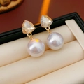 Macro di orecchini a perno a triangolo dorati con cristalli e perle in una scatola - Perno in argento - Oro - Giallo