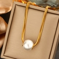 Elegant gold snake chain necklace featuring a round white pearl pendant in a jewelry box - Gold Pearl Snake Chain