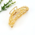 Macro shot of gold metal banana hair claw clip with yellow raw crystal stone decoration - Gold + Citrine