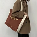 Detail of large brown canvas tote bag with London Review of Books print on a model - Red