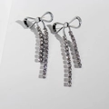 Sparkling silver bow knot fringe earrings with dangling rhinestones on white background - White Gold