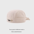 Close-up of baby beige ribbed cotton hat with Take embroidery and cute bear patch - 48cm / Beige