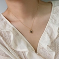 Elegant gold titanium necklace with black oval stone pendant worn on a model - H10091 Black Mirror Oval Necklace Gold