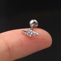 Detailed close-up of a lightning bolt stud earring with zircons held on a fingertip - Flash / Silver (Lightning)