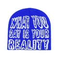 Detail van de koningsblauwe muts met witte WHAT YOU SAY IS YOUR REALITY jacquardtekst - M (56-58cm) / Koningsblauw
