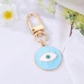 Detail des blauen Emaille Evil Eye Anhängers mit goldenem Schlüsselanhänger - Blaues Wimpern-Emaille-Auge