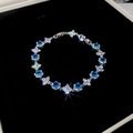 Detalle de pulsera de flores de circón con piedras azules sobre fondo de terciopelo - Azul