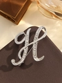 Elegant silver letter H brooch with sparkling rhinestones on a brown leather surface - Silver Letter H