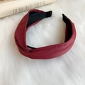 Wide burgundy faux leather knot headband with soft textured finish on white fur background - Deep Plum Red